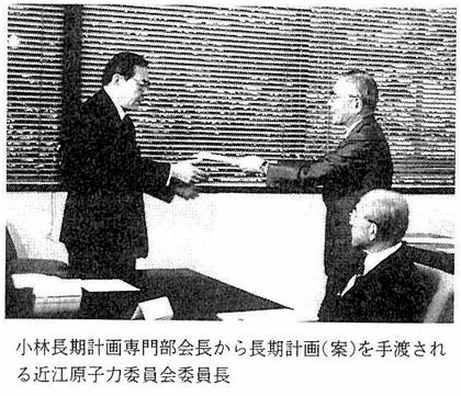 小林長期計画専門部会長から長期計画（案）を手渡される近江原子力委員会委員長